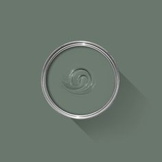 a can of green paint with a long shadow on the wall, and a circular object in the middle