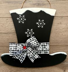 a black and white cowboy hat with snowflakes on the side, hanging from a rope