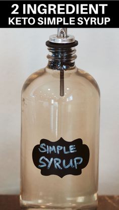 a glass bottle with the words simple syrup on it and an image of a black sticker that says, 2 ingredient keto simple syrup