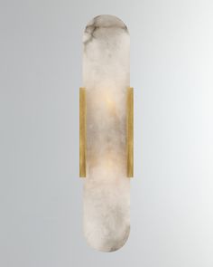 a white marble light fixture with gold trim on the back and sides, against a gray background