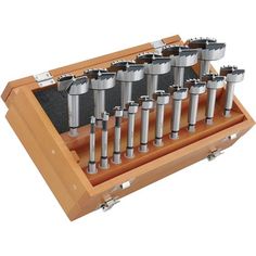 a wooden box with eight different sized metal objects in it's tray and the lid is open