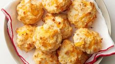 a white plate topped with cheesy biscuits on top of a red and white cloth