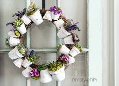 a wreath with flowers and marshmallows hanging on a door