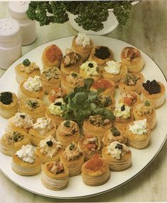 a white plate topped with lots of different types of appetizers on top of a table