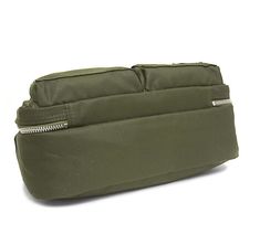 an olive green bag with zippers on the front and side, sitting on a white surface