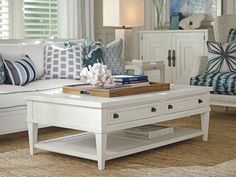 a white coffee table with blue and white pillows