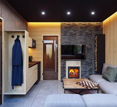 a living room filled with furniture and a fire place next to a wall mounted tv