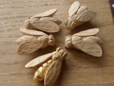 four wooden bees are sitting on a table