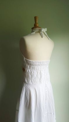 Embroidered sunflowers pop on this gorgeous white cotton-gauze dress. The lacy bodice flares into an ultra-full, handkerchief-hem skirt, with white satin ribbon accents. Easy fit, with a ruched, elasticized back and halter tie at neck. Best fits medium/large sizes. Era: 1970s Label: none ➸ visit on instagram | provenance_vintage Cotton Ruffle Halter Neck Dress, Cotton Halter Neck Dress With Ruffles, White Ruffled Halter Neck Dress, White Halter Neck Dress With Ruffles, White Backless Halter Sundress, White Fitted Bohemian Halter Dress, White Ruffled Halter Neck Sundress, White Halter Neck Sundress With Ruffles, Bohemian Halter Dress With Smocked Back