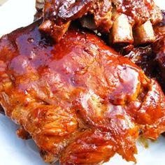 ribs covered in bbq sauce on a white plate