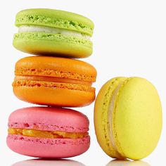 a stack of colorful macaroons sitting next to each other on a white surface