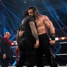 two men standing next to each other in a wrestling ring