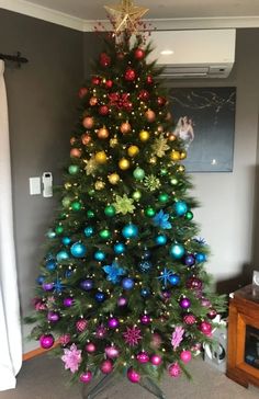 a brightly colored christmas tree in a living room