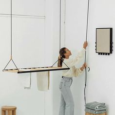 a woman is hanging on the wall with her hands