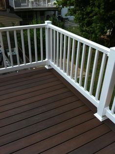 a wooden deck with white rails and railings