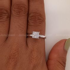 a woman's hand with a diamond ring on it