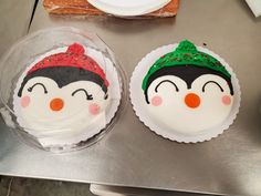 two decorated cupcakes sitting on top of a metal counter next to each other