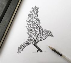 a pencil drawing of a tree on top of a piece of paper next to a pen