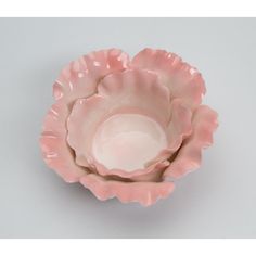 a pink flower shaped bowl sitting on top of a table