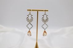 Discover the perfect balance of elegance and whimsy with our Filigree Dangling Peach Stone Earrings. Crafted with expertly faceted fancy cut cubics, these earrings add a touch of sparkle to any outfit. The intricate filigree design showcases the delicate peach stone, creating a timeless and sophisticated look. Length: 2.30” Width: 0.78” Closure: Fish Hook Material: Brass with 18K Gold Plating with Rhodium Coating Lead Free and Hypoallergenic Elegant Gold Faceted Crystal Earrings, Elegant Rose Gold Pierced Crystal Earrings, Elegant Faceted Chandelier Earrings, Elegant Faceted Dangle Teardrop Earrings, Elegant Faceted Teardrop Dangle Earrings, Elegant Faceted Earrings For Party, Elegant Nickel-free Crystal Earrings, Elegant Faceted Party Earrings, Elegant Rose Gold Chandelier Earrings