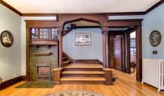 an ornate entry way with wood floors and blue walls is flanked by wooden staircases that lead up to the second floor