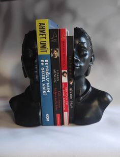 a black busturine holding three books in it's head