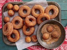 doughnuts are on a tray with sugar and cinnamon sprinkled around them