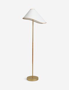 a gold floor lamp with a white shade on the base and a light bulb in the middle