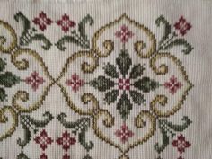 a close up of a piece of cloth with flowers and leaves embroidered on the side