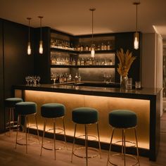 a bar with three stools and several bottles on the shelves behind it in a room