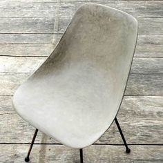 a white chair sitting on top of a wooden floor next to a black metal frame