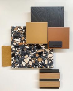 several different colors and shapes of tile on a white wall, including black, brown, yellow, and orange