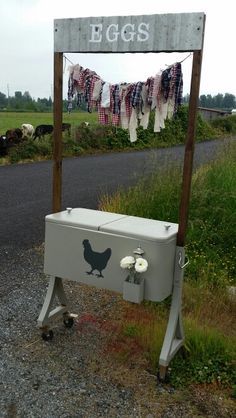 an old cooler sitting on the side of a road next to a sign that says bags