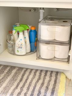 the bathroom cabinet is organized with toilet paper and cleaning products