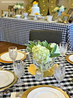 a table set with plates, silverware and flowers in a glass vase on it