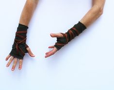 two hands are tied up to each other with black leather wrist wraps on their fingers