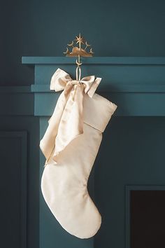 a christmas stocking hanging on a fireplace with a star ornament attached to it