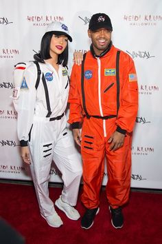 a man and woman dressed in space suits posing for a photo on the red carpet