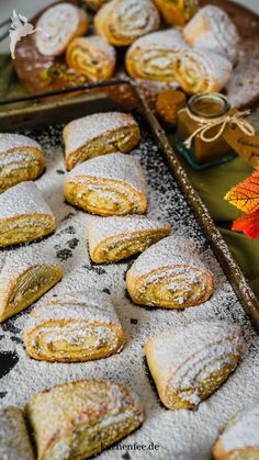 several pastries are on a tray with powdered sugar