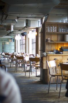 an empty restaurant with wooden tables and chairs