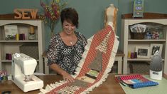 a woman is working on some quilts at a sewing machine in front of her