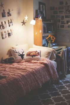 a bedroom with a bed, desk and pictures on the wall