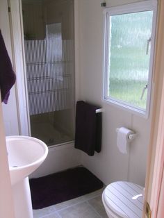 a white toilet sitting next to a shower in a bathroom