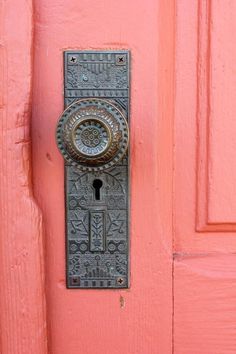 the door is painted pink and has a metal lock on it