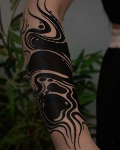 a woman's arm with black and white tattoos on it