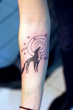 a tattoo on the arm of a woman with a horse and spirals in it