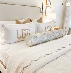 a bed with white sheets and decorative pillows