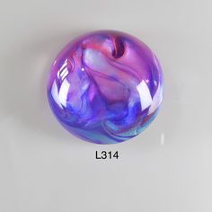 a purple and blue marble ball sitting on top of a table