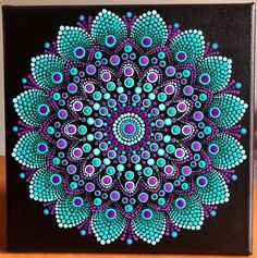 a painting of a purple and blue flower on a black canvas with circles in the center