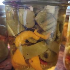 pickles and peppers in a jar on a table